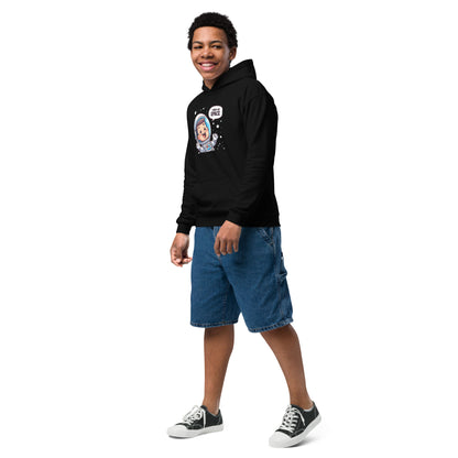 A young person wearing a heavy blend space hoodie with a colorful astronaut design, styled with denim shorts